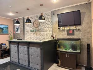 a bar with a fish tank and a tv at Міні-готель RANDEVU in Zhytomyr