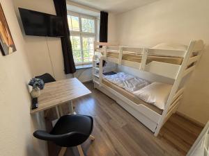 a dorm room with two bunk beds and a desk at Haus zur Eiche Private 1 Zimmerstudios in Chur