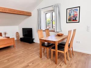 a dining room with a wooden table and chairs at Apartment am Starnberger See in Tutzing