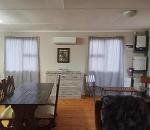 a dining room with a table and chairs and curtains at Bietjierus Guest Cottage in Twee Riviere