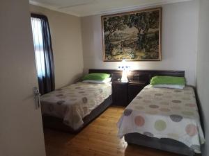 a bedroom with two beds and a picture on the wall at Bietjierus Guest Cottage in Twee Riviere