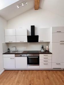 a kitchen with white cabinets and a sink at Apartment am Starnberger See in Tutzing