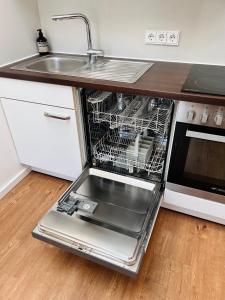 an empty dishwasher in a kitchen next to a sink at Apartment am Starnberger See in Tutzing +5 photos