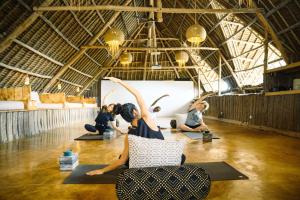 a group of people doing yoga in a room at Zanzibar Sunrise at Bandas in Matemwe