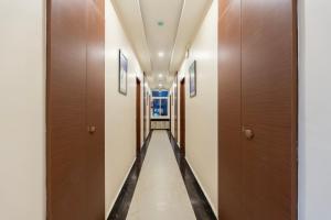 a corridor of a hallway with wooden doors at Treebo Skanda Grande in Pondicherry