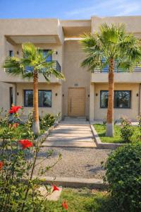 a house with two palm trees in front of it at Atlas villa c3 in Sraghna