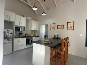 a kitchen with white cabinets and a black counter top at Sunset Sands in St. Helena Bay