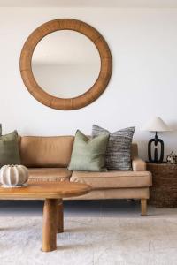 a living room with a couch and a mirror at Postcard on Sunrise in Sunrise Beach