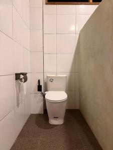 a bathroom with a white toilet in a stall at Mu Homestay Tetebatu in Tetebatu