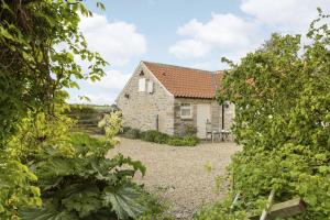 a stone cottage with a garden in front of it at Applewood in Harome
