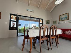 a dining room with a table and a red couch at Sunset Sands in St. Helena Bay