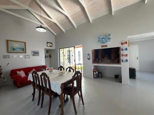 a dining room with a table and a red couch at Sunset Sands in St. Helena Bay