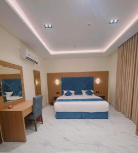 a hotel room with a bed and a desk and a bed sidx sidx sidx sidx at الديار الفاخرة للشقق المخدومة - جيزان in Jazan