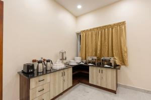 a kitchen with a counter with appliances on it at Treebo Skanda Grande in Pondicherry +23 photos