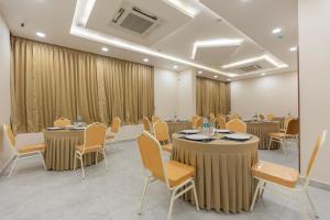 a conference room with tables and chairs and curtains at Treebo Skanda Grande in Pondicherry