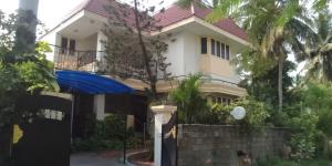 a house with a blue gate in front of it at Coral Shelters Service Apartments Thuvariman in Madurai