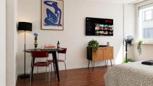 a room with a table and two chairs and a tv at Central Studio Apartment with free BaselCard - Magritte in Basel