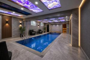 a swimming pool in a hotel with lights on the ceiling at Valor Hotel in Tashkent