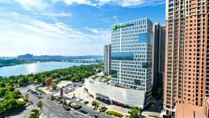a view of a city with tall buildings and a river at Holiday Inn Express Linyi Riverside by IHG in Linyi