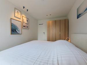 a bedroom with a large white bed in it at Flat Sealodge - Koksijde in Sint-Idesbald