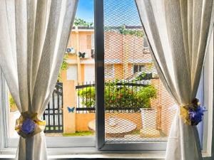 a window with curtains and a view of a building at Fantasia House General Santos in Lagao II