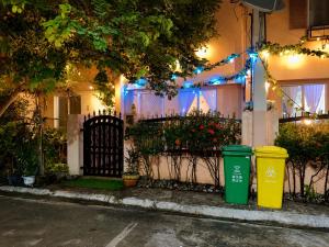 a house with two trash cans in front of a fence at Fantasia House General Santos in Lagao II