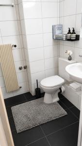 a bathroom with a white toilet and a sink at Central Studio Apartment with free BaselCard - Magritte in Basel