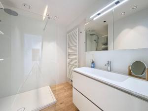 a white bathroom with a sink and a mirror at Flat Sealodge - Koksijde in Sint-Idesbald +43 photos