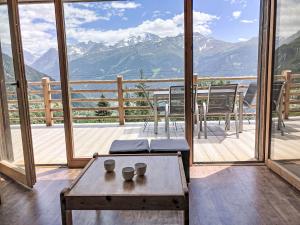 a room with a table and a balcony with mountains at Chalet Château Lapin by Interhome in Verbier