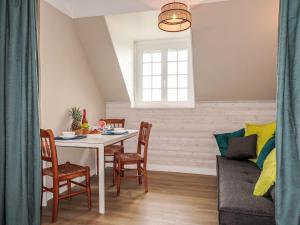 a dining room with a table and chairs and a couch at Holiday Home Les Blés by Interhome in Plozévet