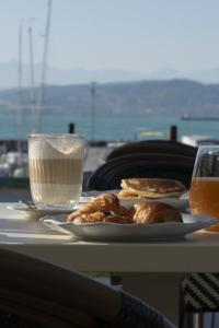 ein Tisch mit zwei Tellern Essen und einem Glas Milch in der Unterkunft Pattùs Hôtel in Saint Aubin Sauges