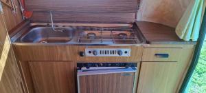 a small kitchen with a sink and a stove at Chez Flo&Fred Caravane Vintage in Barbery