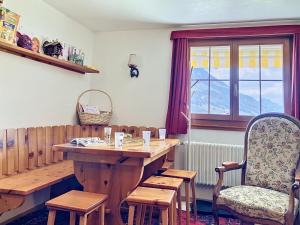 a room with a wooden table and a chair at Apartment Chalet Clairval by Interhome in Charmey