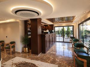 a lobby with a bar with green chairs and windows at Ovva Inn Yeşilovacık Hotel in Dibekli