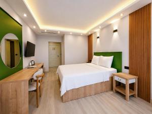 a bedroom with a bed and a desk and a television at Ovva Inn Yeşilovacık Hotel in Dibekli