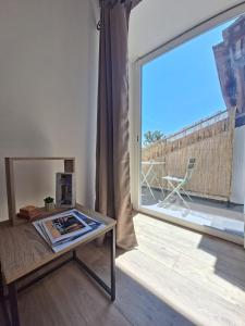 a living room with a table and a large window at La Voûte - Clim et Gare 5 min in Rumilly