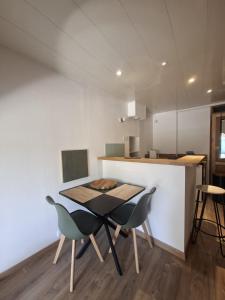 a kitchen with a table and chairs in a room at La Voûte - Clim et Gare 5 min in Rumilly