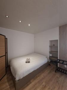 a bedroom with a bed with a pair of shoes on it at La Voûte - Clim et Gare 5 min in Rumilly