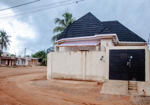 a building with a black garage door on a dirt road at La Cas'a Yehud in Aoudja