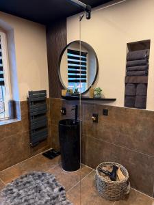 a bathroom with a shower with a round mirror at 4 Rooms Pixel A in Herzebrock +12 photos
