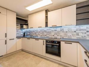 a kitchen with white cabinets and a stove top oven at Apartment Wohnung Muntegn by Interhome in Vicosoprano
