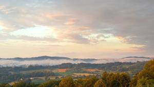 a view of a valley with clouds and trees at Apartman Domaja in Viča