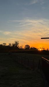 a sunset in a field with a fence at Apartman Domaja in Viča