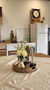 a table with a basket with flowers and a clock at Apartman Domaja in Viča