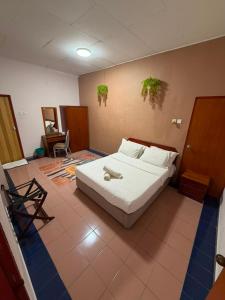 a bedroom with a white bed in a room at Bunga Raya Resort Parit Buntar in Parit Buntar