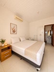a bedroom with a large bed and a bathroom at Pousada Escarpas in Capitólio +49 photos