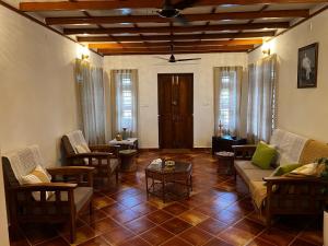 a living room with couches and chairs and a table at Haritham Heritage Villa in Vadakkāncheri