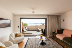 a living room with a couch and a table at Hôtel & Spa Rocabella in LʼÎle-Rousse