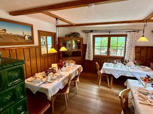 a dining room with two tables with white tablecloths at Gasthof Kronreith in Maria Alm am Steinernen Meer
