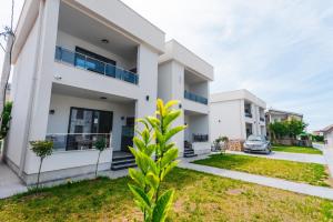 a white house with a green yard at Bumax Apartments in Ulcinj